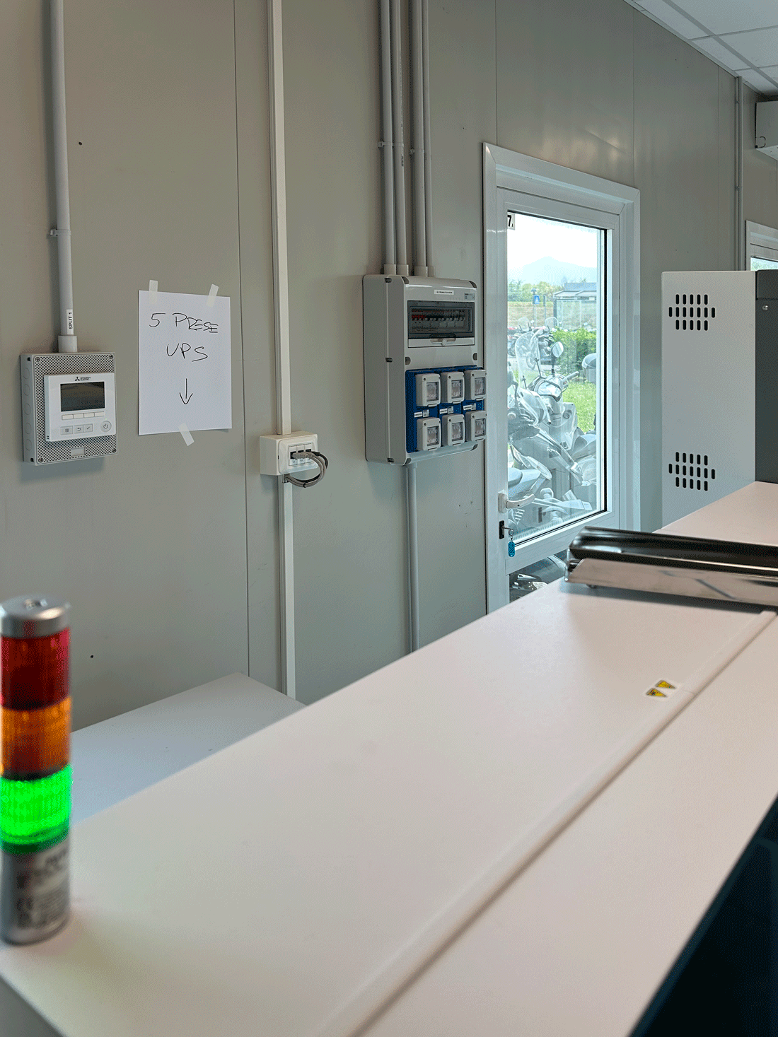 Postazione tecnica con quadri elettrici secondari, termostato Mitsubishi e indicazione prese UPS.
