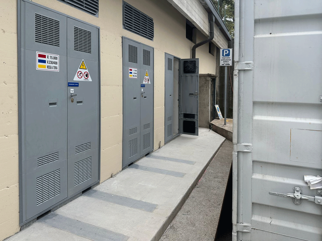 Porte metalliche con segnaletica di pericolo per alta tensione dei locali tecnici esterni.
