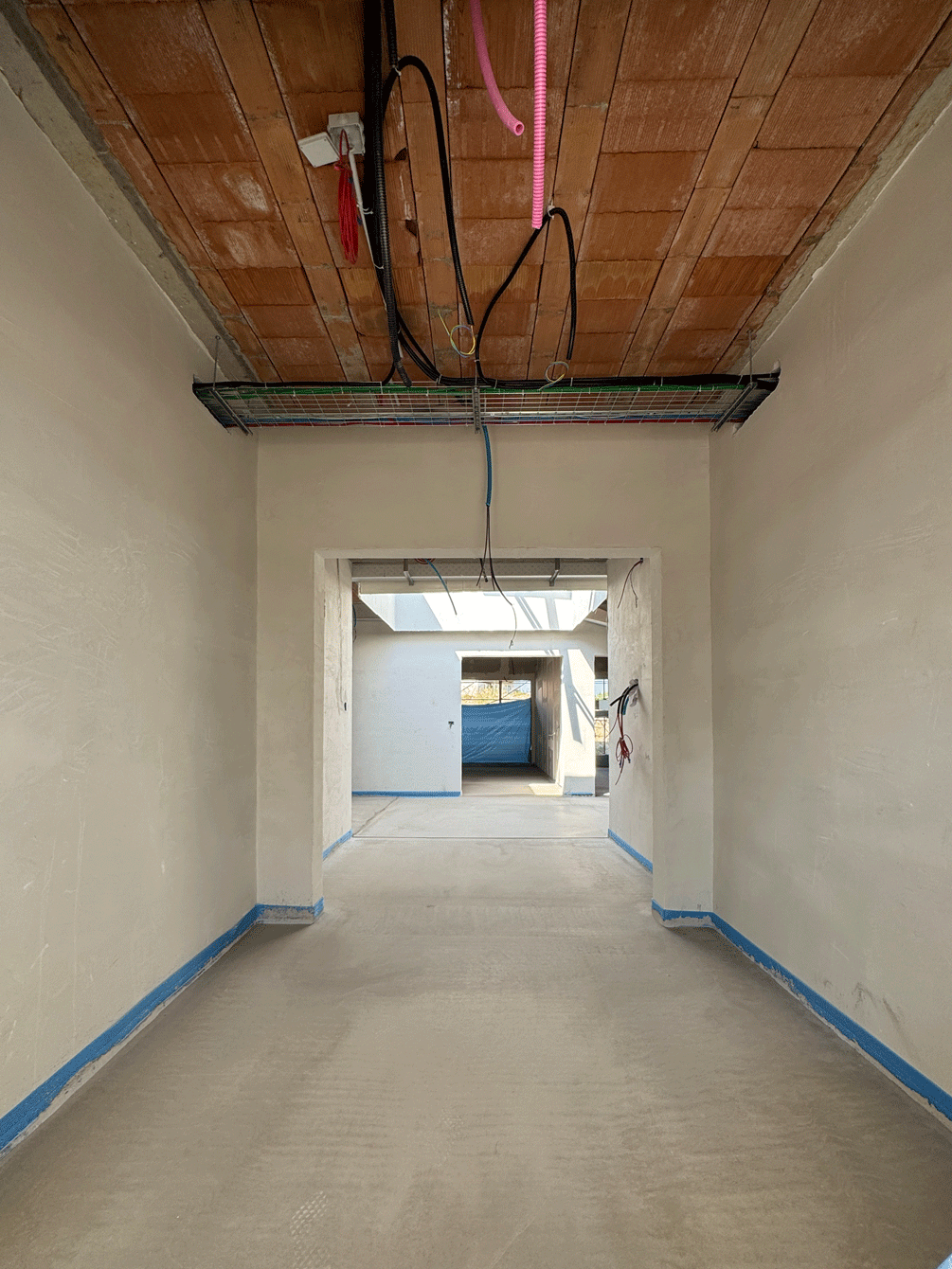 Corridoio interno del nido d'infanzia Melograno con intonaci ultimati e predisposizione impianti a soffitto.