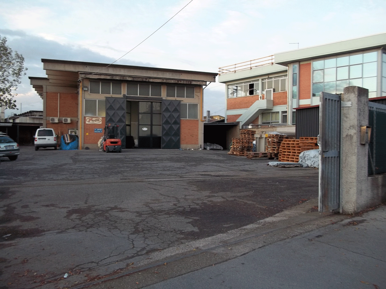 Area esterna e cortile della Conceria Mangusta con bancali in legno e muletto pronti per le operazioni logistiche.