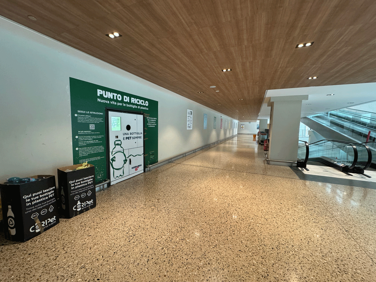 Corridoio interno Esselunga Varese con punto di riciclo PET e soffitto in legno.
