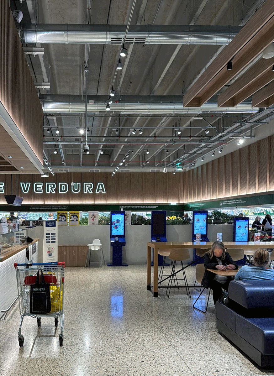 Interni zona ristoro Esselunga Varese con impianti di aerazione e illuminazione a vista.