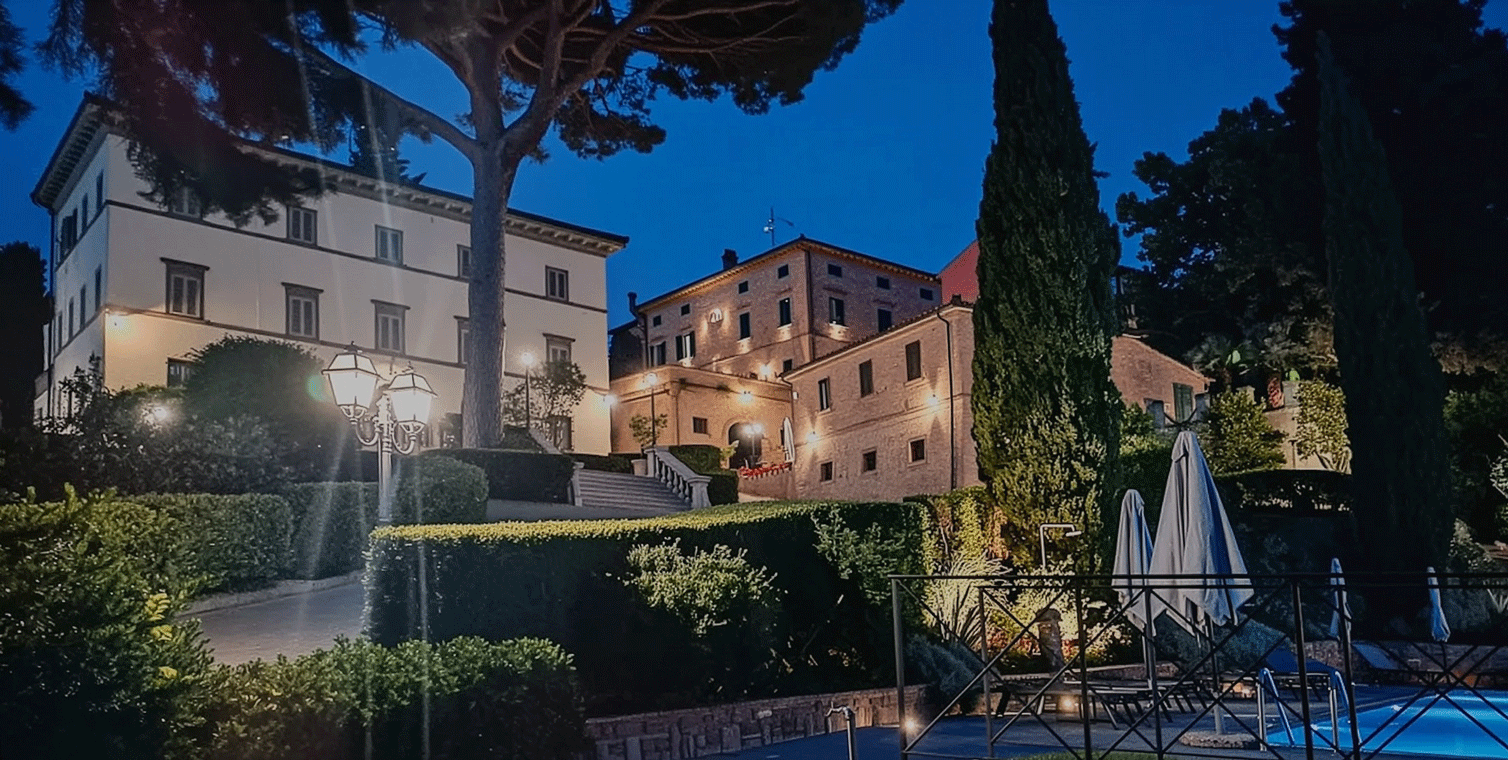 Facciate degli edifici dell'agriturismo Bucciano illuminate di sera.