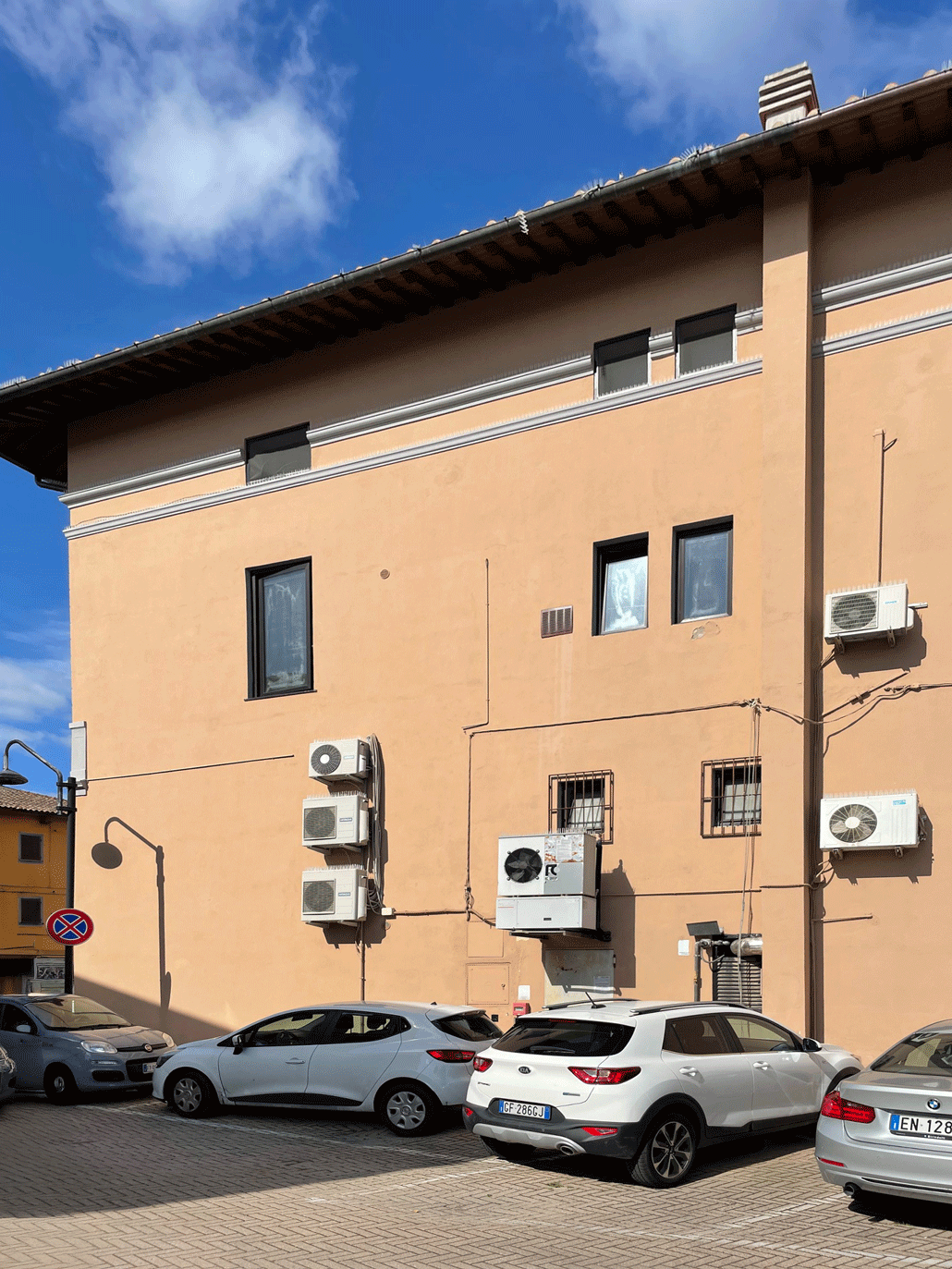 Parete posteriore dell'edificio comunale con numerosi motori esterni per il condizionamento dell'aria.