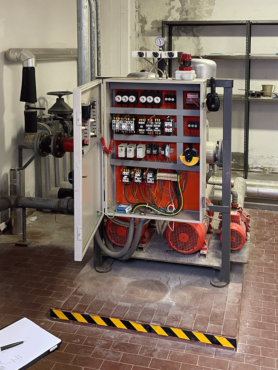Quadro elettrico aperto e gruppo di pressurizzazione antincendio all'interno del locale pompe della base.