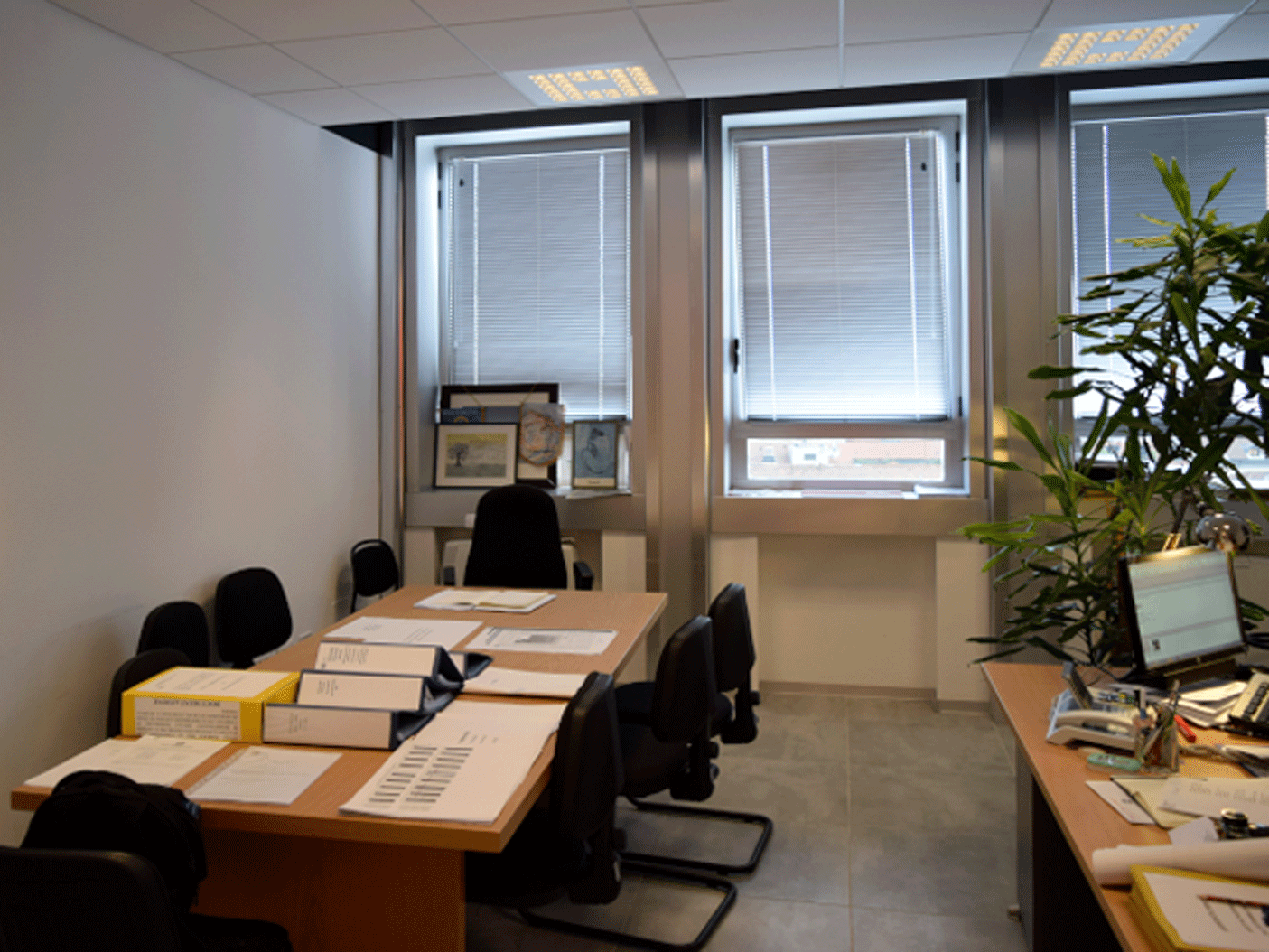 Sala riunioni moderna con pannelli LED a incasso e postazioni di lavoro cablate.