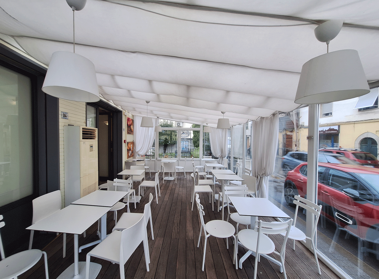 Panoramica della veranda a vetrate e corpi illuminanti della pasticceria.