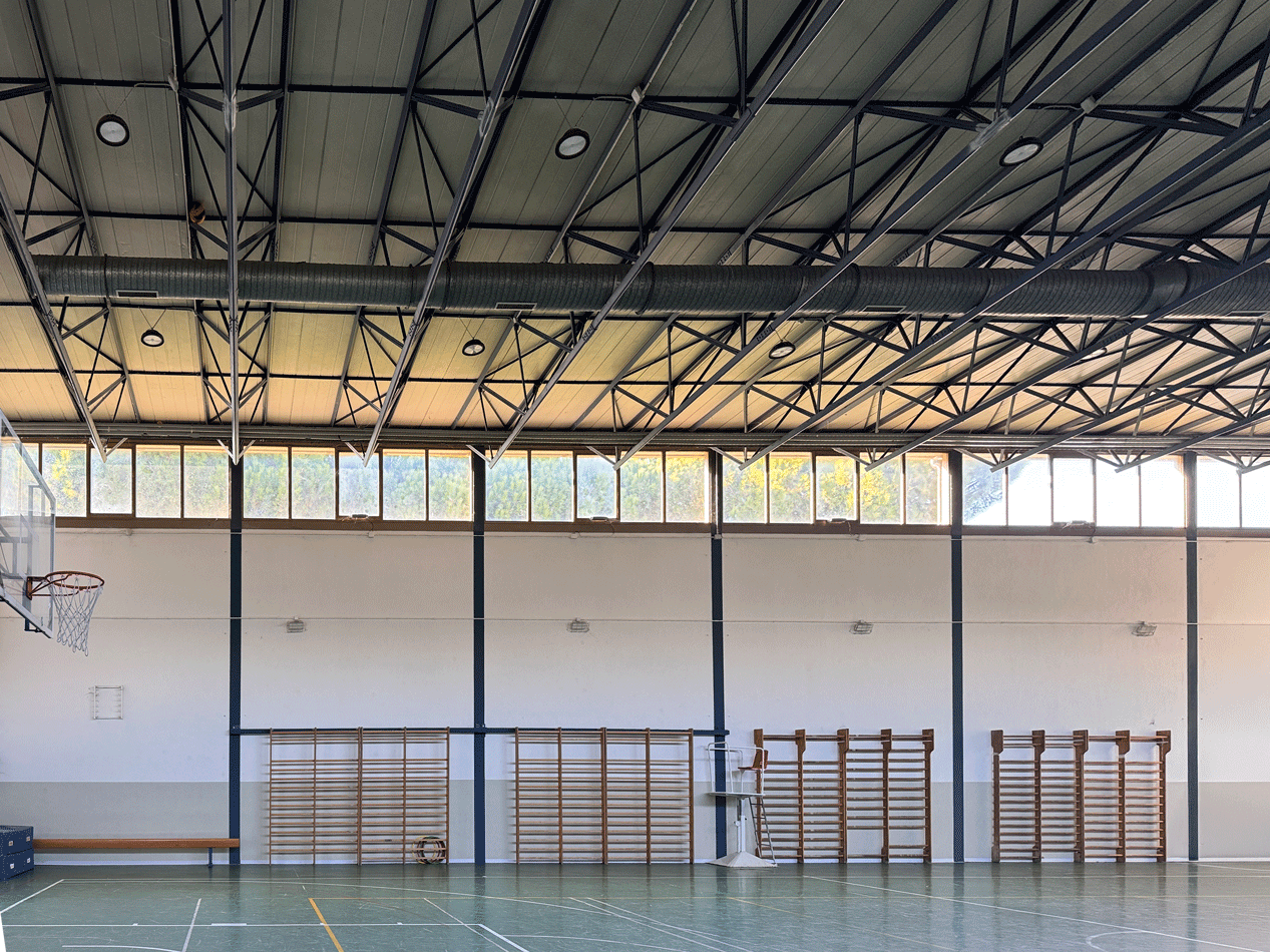 Vista interna della palestra con copertura e impianto di distribuzione a vista.