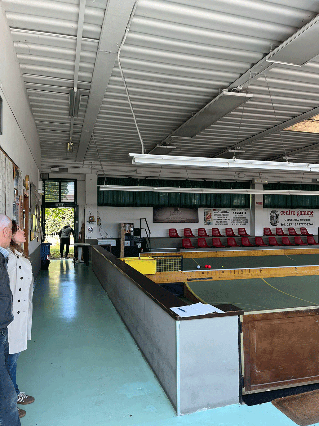 Interno del bocciodromo con area di gioco, tribune laterali e illuminazione della struttura.
