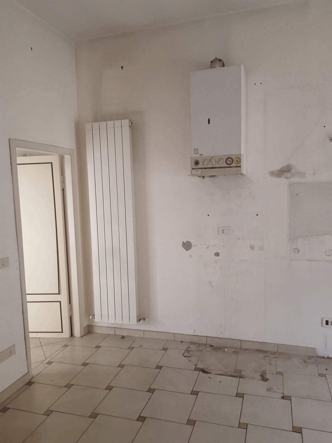 Locale interno con caldaia murale e radiatore in un appartamento Siena Casa.